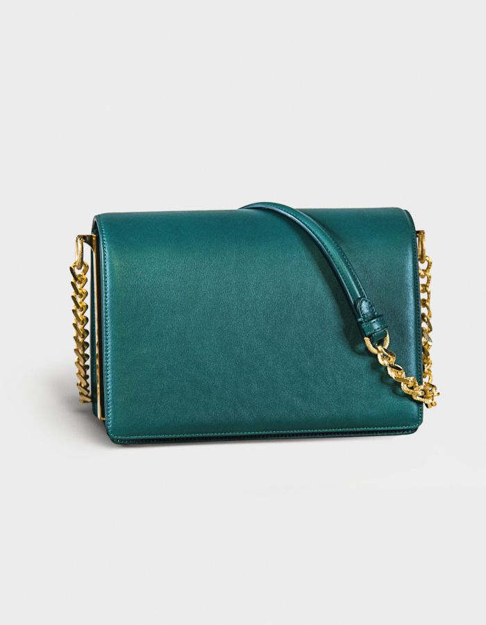 Elegant teal handbag with gold chain strap.